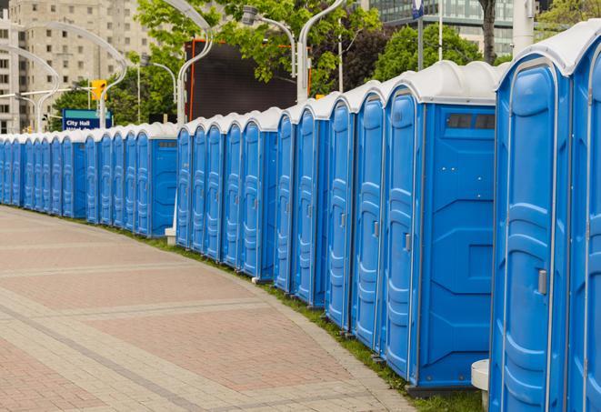 a row of portable restrooms set up for a large athletic event, allowing participants and spectators to easily take care of their needs in Indian Lake